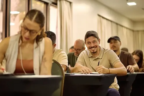 Participante sorrindo enquanto anota
